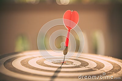 The bullseye, or bull`s-eye or dart board has dart arrow hitting the center of a shooting target for business targeting Stock Photo