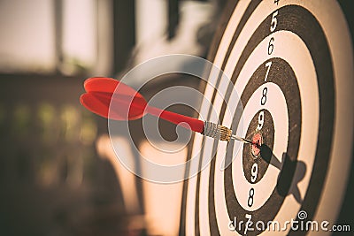 The bullseye, or bull`s-eye or dart board has dart arrow hitting the center of a shooting target for business targeting Stock Photo