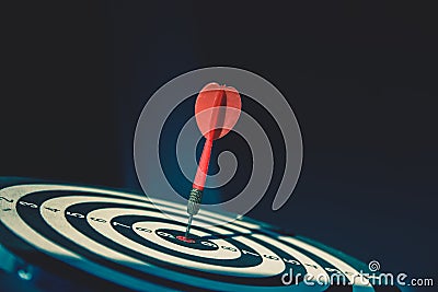 Bullseye or dart board has dart arrow throw hitting the center of a shooting target for business targeting Stock Photo