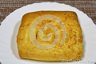 Bun on a white plate on the table. Stock Photo