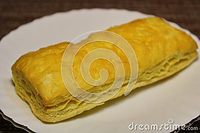 Bun on a white plate on the table. Stock Photo