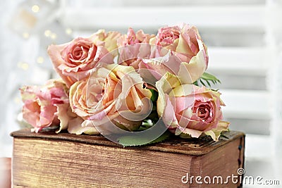 Bunch of multicolor roses lying on old book Stock Photo