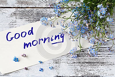 Bunch of blue flowers forget-me-nots and good morning note Stock Photo