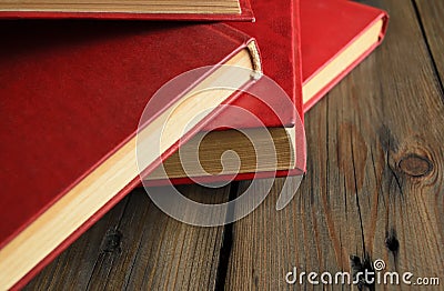 A bunch of books with a scarlet cover on a wooden table. Red books are thrown on the table. books with a red cover lie Stock Photo