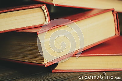 A bunch of books with a scarlet cover on a wooden table. Red books are thrown on the table. books with a red cover lie Stock Photo