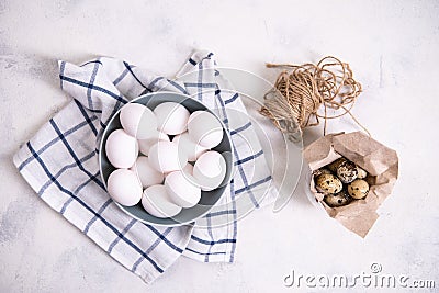 A bunch of brown quail eggs in a transparent bowl and a bunch of white chicken eggs in a blue bowl. Preparing for Easter Stock Photo