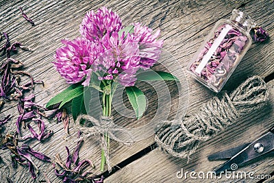 Bunch of clover, bottle with dried herb and jute rope Stock Photo