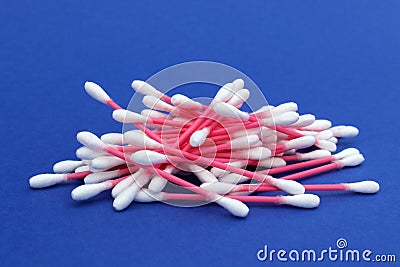 A bunch of cotton buds lie on a blue background. Stock Photo