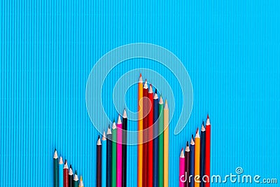 A bunch of crayons in small columns on a blue background, shot from above , arranged at the bottom, closeup Stock Photo