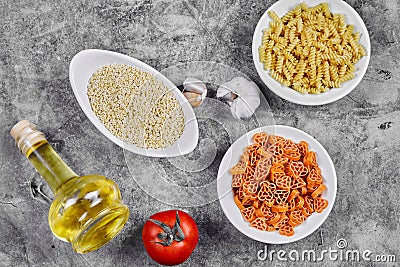A bunch of different shaped uncooked pasta bowls on marble table Stock Photo