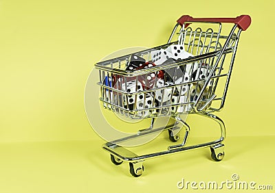 Bunch of different size and color dice placed inside a miniature metallic shopping cart Stock Photo