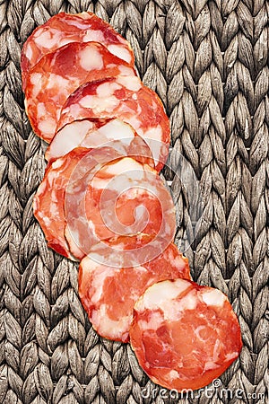 Bunch Of Eight Pork Salami Slices Set On Rustic Vintage Raffia Place Mat Grunge Surface Stock Photo