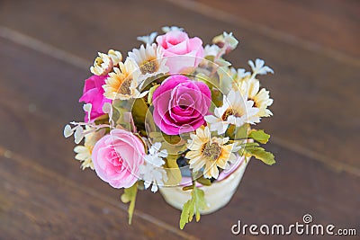 Bunch of flower in a vase is on the wooden floor / specific focus on pink rose. Stock Photo