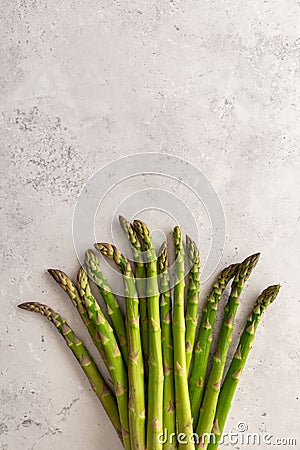 A bundle of fresh green asparagus on a grey background, copy space, vertical Stock Photo