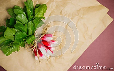 A bunch of freshly picked red radishes on crumpled kraft paper. Growing vegetables, harvesting Stock Photo