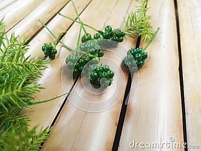 Bunch of Green Coriander Seeds Decorated with Green Grass on Bamboo Surface Stock Photo