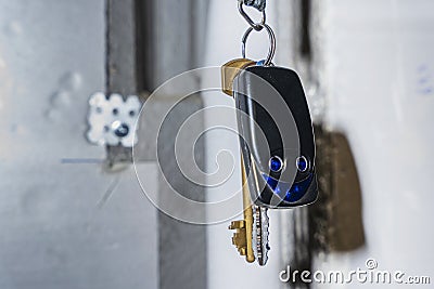 a bunch of keys and a keychain with buttons hang on a hook Stock Photo