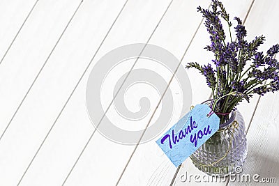 Bunch of lavender in a glass lantern jar, with thank you written on a blue gift label. Stock Photo