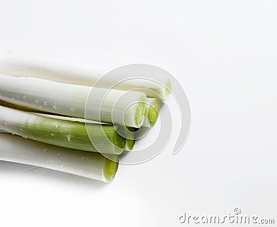 A bunch of leeks piled on a white table Stock Photo