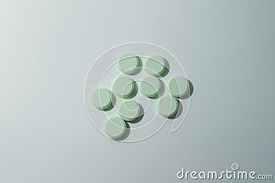 A bunch of medicinal pills and antibiotics, White medical tablets, light green, with copy space Stock Photo