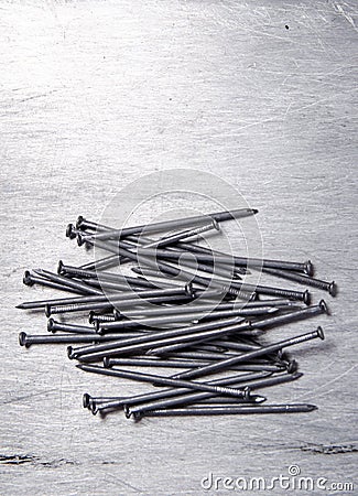 A bunch of metal nails on the alluminium background. vertical vi Stock Photo