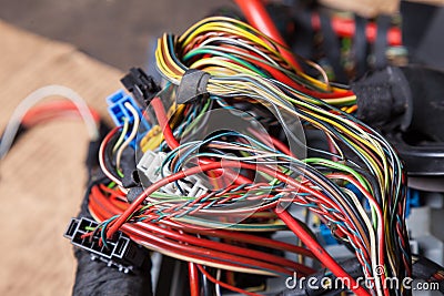 A bunch of multi-colored electrical wires interconnected in the nodes of a car during network repair by an engineer or mechanic in Stock Photo