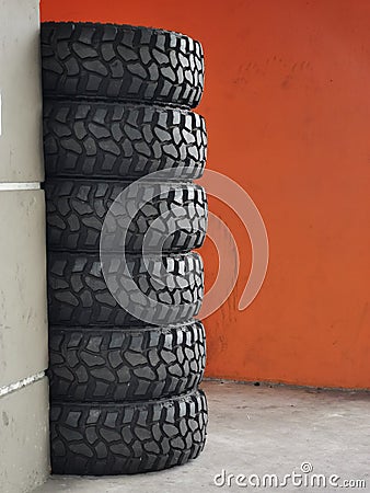 A bunch of new pickup truck rubber tyres stack together on concrete floor. Stock Photo