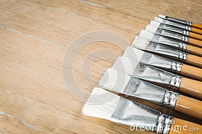 Bunch of old artist paintbrushes on wooden rustic table with space for text Stock Photo