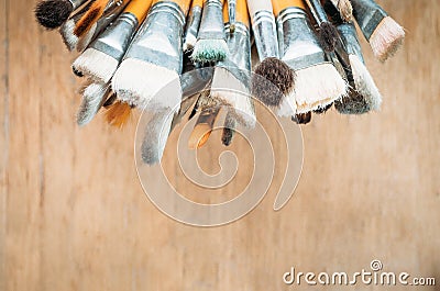 Bunch of old artist paintbrushes on wooden rustic table with space for text Stock Photo