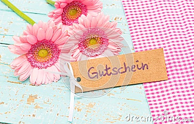 Gift card with german word, Gutschein, means voucher or coupon and beutiful pink flowers Stock Photo