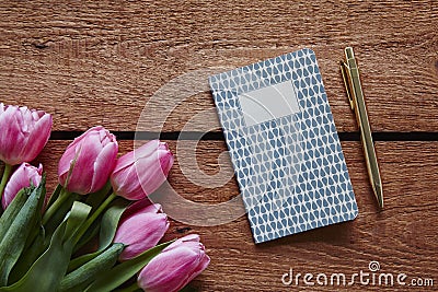 A bunch of pink tulips writing in a notebook spring atmosphere Stock Photo