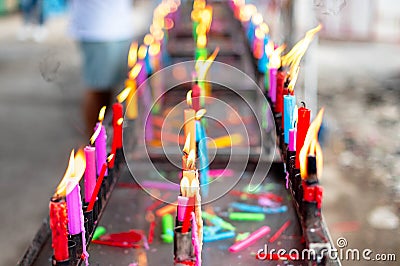 Bunch of prayers candle flames glowing in the Buddhist temple. Symbol of the spiritual atmosphere Stock Photo