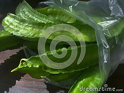 Winged beans or four-angled beans on wooden table Stock Photo