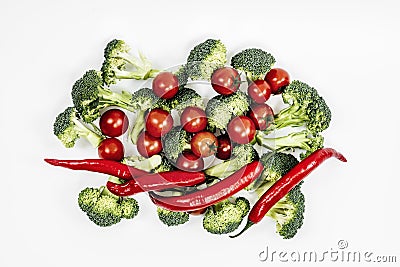 A bunch of red hot peppers with pieces of broccoli and ripe cherry tomatoes Stock Photo