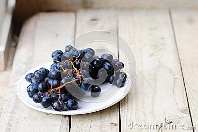 Bunch of ripe blue grapes on a light wooden background Stock Photo
