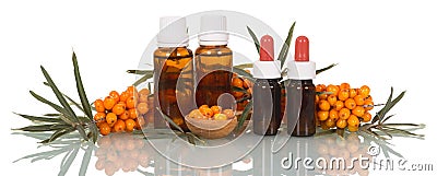 Bunch of ripe sea-buckthorn berries and wooden spoon, bottled oi Stock Photo