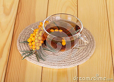 Bunch sea buckthorn and cup tea on background light wood. Stock Photo