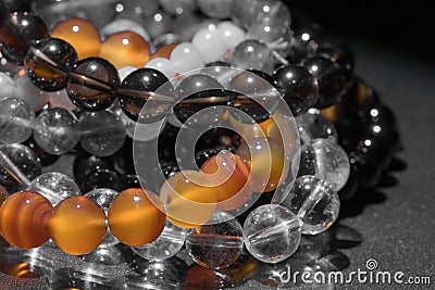 Bunch of semiprecious gemstone bracelets on black background - cornelian, amethyst, quartz Stock Photo