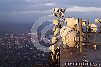 Bunch of transmitters and aerials on the telecommunication tower during sunset Stock Photo