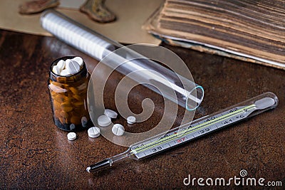 Bunch of white pills with glass ampoules, thermometer Stock Photo