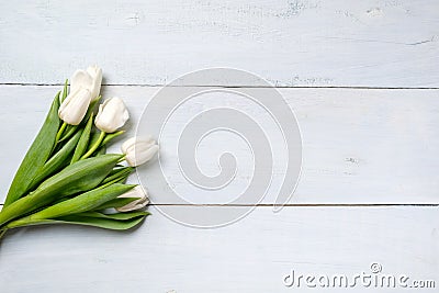 Bunch of white tulips on blue wooden table. Banner mockup card with copy space for congratulation, woman or mother day, easter, sp Stock Photo