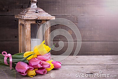 Bunch yellow and pink spring tulips and candle in lantern on v Stock Photo