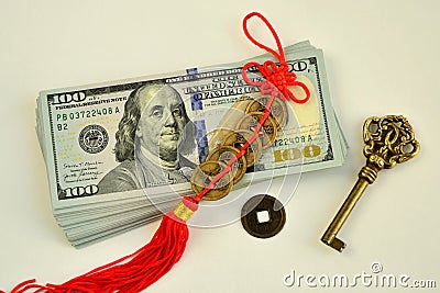 A bundle of 100 dollar bills a key and chinese coins talismans to attract wealth and success Stock Photo