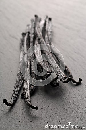 Bundle of dried bourbon vanilla beans or pods on black stone board Stock Photo