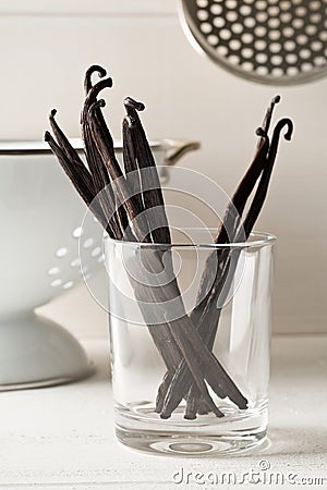 Bundle of dried bourbon vanilla beans or pods in glass on white kitchen background Stock Photo