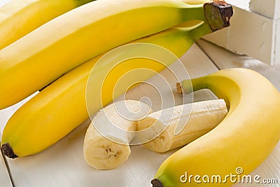 Bundle of fresh, ripe, yellow bananas with sliced banana pieces Stock Photo