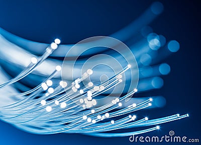 Bundle of optical fibers with lights in the ends. Blue background Stock Photo