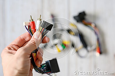 A bundle of wires with different connections in a hand against a background of a pile of various electronic wires. selective focus Stock Photo