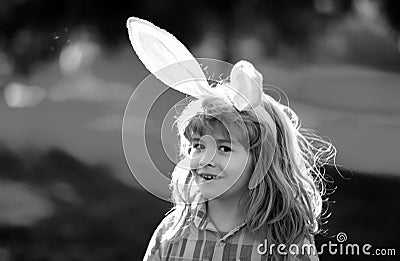 Bunny child boy face. Child boy hunting easter eggs. Cute kid in rabbit costume with bunny ears having easter in park. Stock Photo