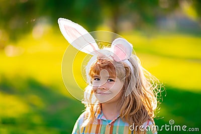 Bunny child boy face. Easter bunny children. Kids boy in bunny ears in park outdoor. Stock Photo